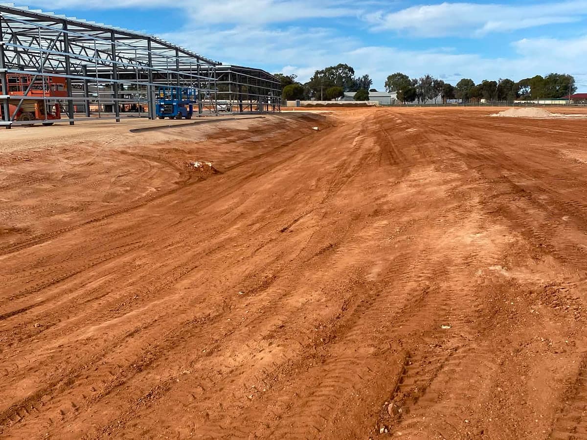 Levelled site with a steel building frame behind