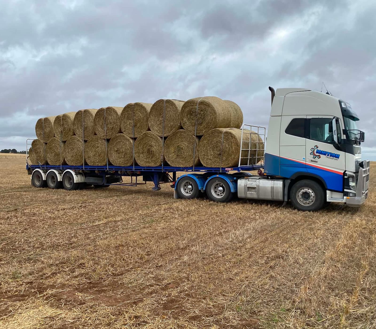 Semi loaded with hay bales in a paddock