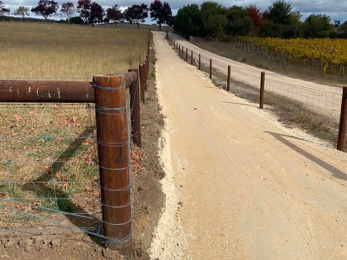 Gravel driveway running beside a paddock fence