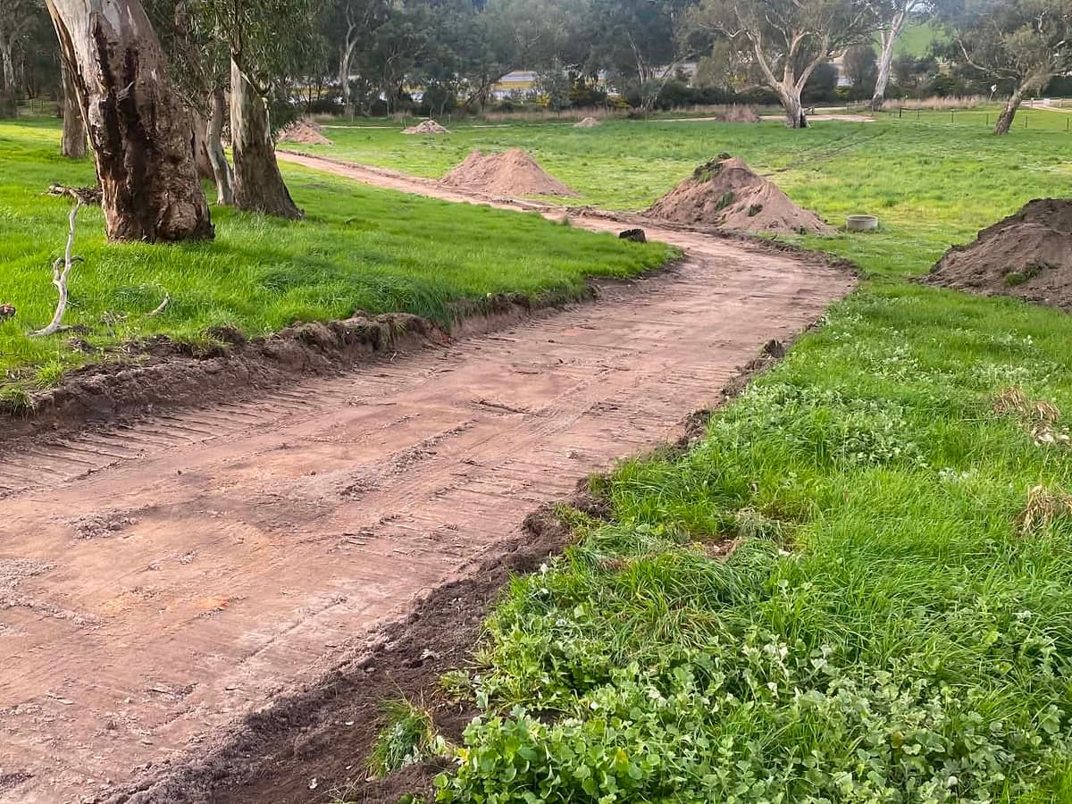 Freshly cut farm track winding through a paddock