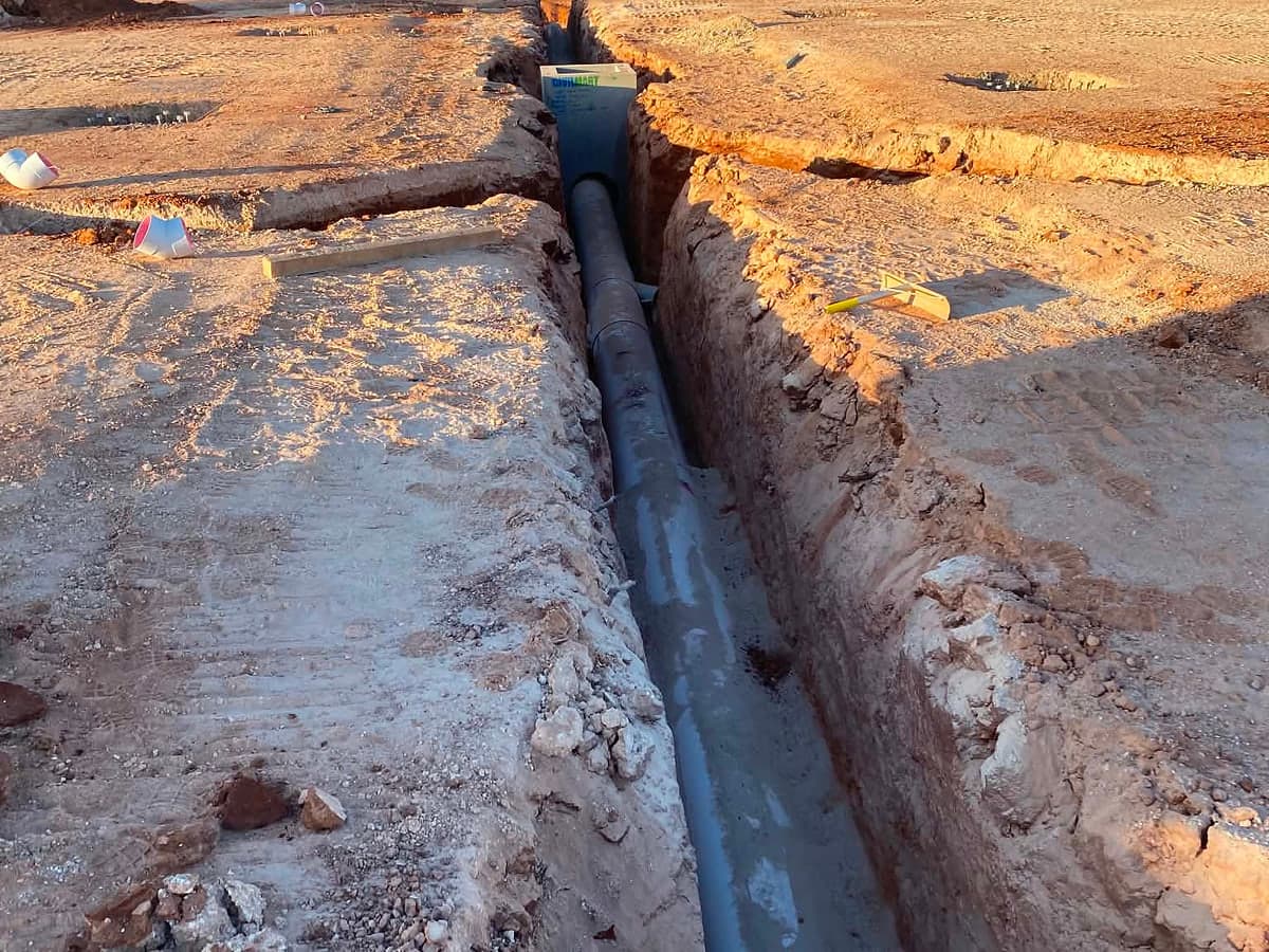 Trench with pipe laid for site drainage